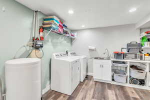 Laundry room featuring dark wood-style flooring, washing machine and dryer, and recessed lighting