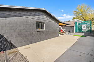 View of property exterior featuring concrete block siding and a patio