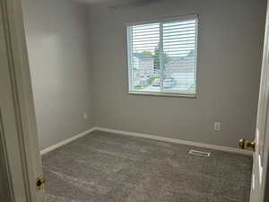 Spare room featuring carpet floors and baseboards