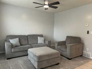 Tiled living room with baseboards and a ceiling fan
