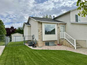 Rear view of property featuring a gate and a shingled roof