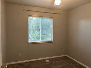 Carpeted spare room featuring baseboards and a textured ceiling