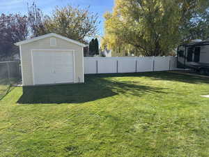 Fenced backyard with an outbuilding