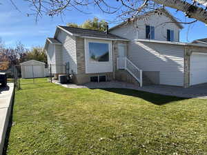 Split level home with a patio area, a gate, and an attached garage