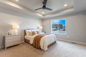 Bedroom featuring a raised ceiling, carpet, ceiling fan, and recessed lighting