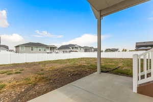 Fenced backyard with a residential view and a patio area