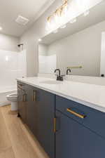 Full bathroom with vanity, light wood finished floors, and shower / bathtub combination