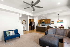 Living room featuring recessed lighting, ceiling fan, light wood-style flooring, and light carpet