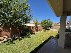 Fenced backyard with a patio and a storage unit