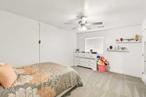 Bedroom with light colored carpet and ceiling fan