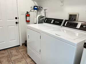 Laundry room featuring light tile patterned flooring and separate washer and dryer