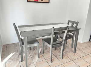 Dining space featuring light tile patterned flooring and baseboards