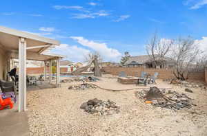 Fenced backyard with a patio area, a fire pit, and outdoor dining area