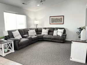 Carpeted living area with recessed lighting and ceiling fan