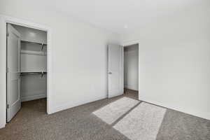 Unfurnished bedroom with carpet floors and a walk in closet