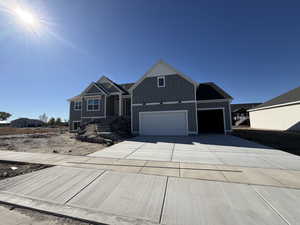 Craftsman inspired home featuring driveway, board and batten siding, and a garage