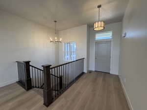 Foyer featuring light wood-style flooring, a chandelier, and a textured ceiling