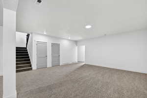 Finished below grade area featuring carpet floors, stairway, recessed lighting, and a textured ceiling