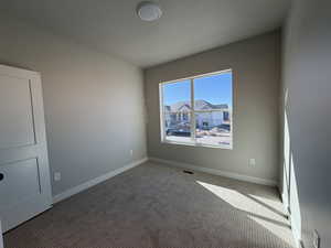 Empty room featuring carpet floors and baseboards