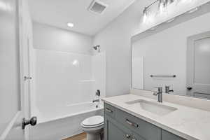 Full bath featuring washtub / shower combination, vanity, and a textured ceiling