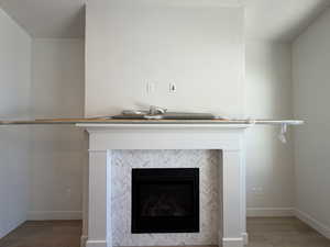 Detailed view of a textured ceiling, wood finished floors, and a tiled fireplace