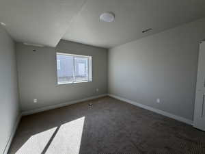 Spare room featuring carpet and a textured ceiling