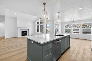 Kitchen with hanging light fixtures, dishwasher, gray cabinetry, a chandelier, and light wood-type flooring