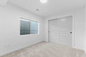 Unfurnished bedroom with a closet and light colored carpet