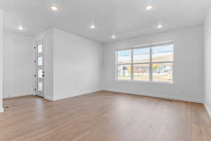 Unfurnished living room with light wood-type flooring and recessed lighting