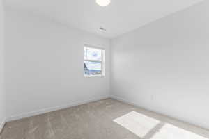 Empty room featuring carpet and baseboards
