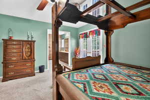 Carpeted bedroom featuring access to exterior, ensuite bath, ceiling fan, and french doors
