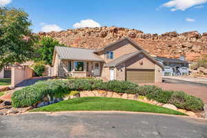 View of front facade featuring brick siding, driveway, a mountain view, stucco siding, and an attached garage