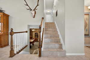 Staircase featuring tile patterned floors and a brick fireplace