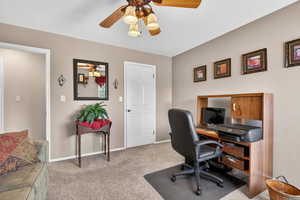Office space with light colored carpet and ceiling fan