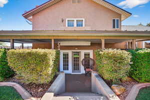 View of exterior entry with stucco siding and a porch