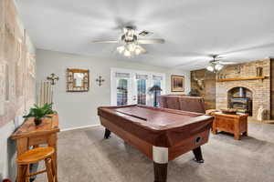 Playroom with carpet floors, ceiling fan, a textured ceiling, french doors, and brick wall