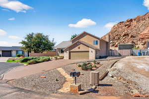 View of front of property with concrete driveway, stucco siding, and a gate