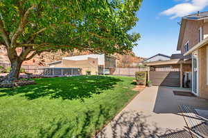 Fenced backyard with a swimming pool and a patio