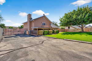 Back of house featuring stucco siding and a chimney