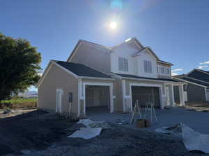 Traditional home featuring an attached garage, driveway, and board and batten siding