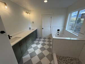 Bathroom featuring double vanity, a garden tub, recessed lighting, and light flooring
