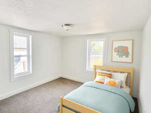 Carpeted bedroom featuring a textured ceiling