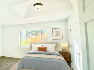 Carpeted bedroom featuring baseboards and a tray ceiling