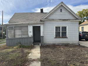 View of front of house with a chimney and roof with shingles
