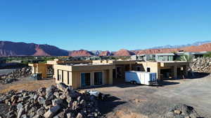 Back of house with a mountain view and stucco siding
