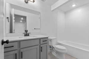 Full bathroom featuring light tile patterned flooring, vanity, bathing tub / shower combination, and a textured ceiling