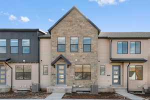 View of front facade with stone siding and roof with shingles