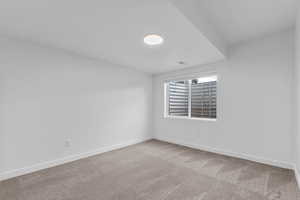 Unfurnished room with light colored carpet and baseboards