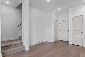 Interior space with recessed lighting, dark wood-style flooring, and stairway
