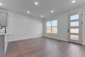 Unfurnished living room featuring recessed lighting and dark wood finished floors